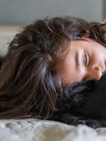 A close-up of a girl resting her head on her sleeping dog, a moment of pure peace and trust.