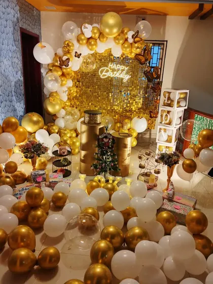 An extravagant gold and white balloon decoration filling an entire room, creating a luxurious and celebratory atmosphere for a home party.