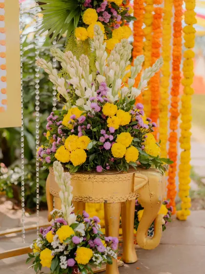 Another angle of the decorative golden elephant stool with a vibrant floral arrangement. These details showcase our commitment to creating a cohesive and beautifully themed event space.