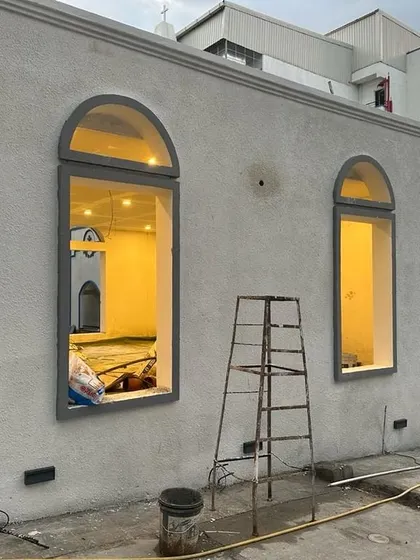 An evening shot of a building under construction at the Good Shepherd Cathedral site. The warm interior light highlights the architectural forms that our landscape will soon complement.