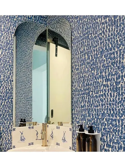 This fun and quirky 'JOY45' wallpaper is perfectly suited for an accent wall or a powder room. The abstract, painterly dots in blue and white add a playful yet sophisticated touch.