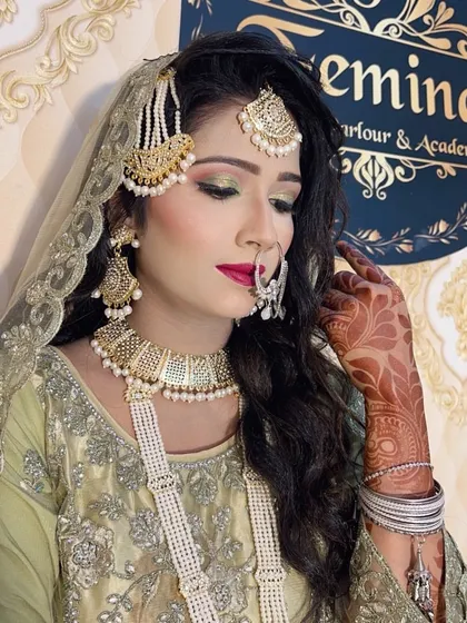 A close-up of the green and gold Muslim bridal look, showing the detailed eye makeup, the placement of the `nath` (nose ring), and the intricate `jhoomar`.