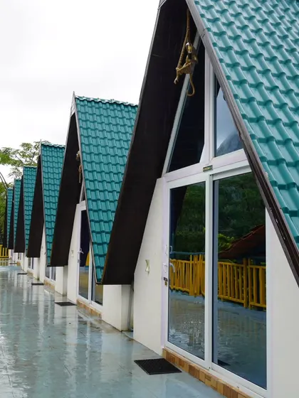 A row of our A-frame cabins at the Nandi Hills property, showcasing their modern design and beautiful setting against the backdrop of palm trees.