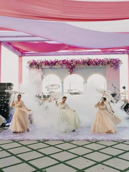 Before the couple's grand entrance, musicians and dancers set a magical scene with smoke effects and parasols, weaving a tapestry of enchanting tunes for the Bridgerton theme.