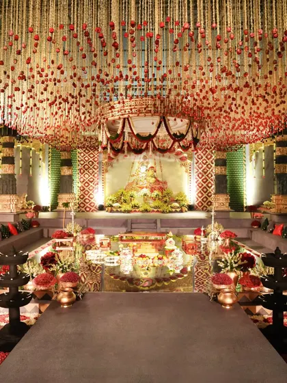 A focused view of the central mandap, highlighting the reflection in the mirrored floor and the intricate floral canopy above. The design creates a sense of divine beauty and opulence, perfect for the sacred wedding rituals.