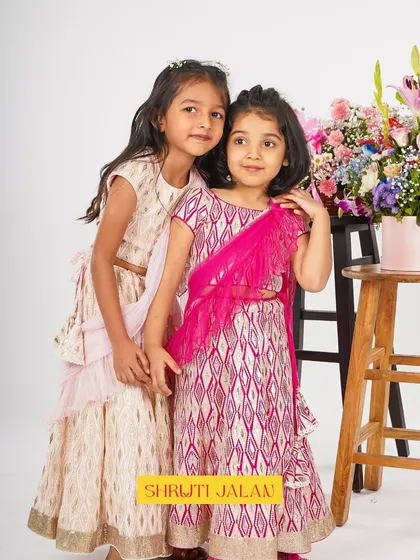 Two sisters posing sweetly in my printed lehengas. The coordinated colors and modern design with a pre-draped dupatta make them a stylish and practical choice for any celebration.
