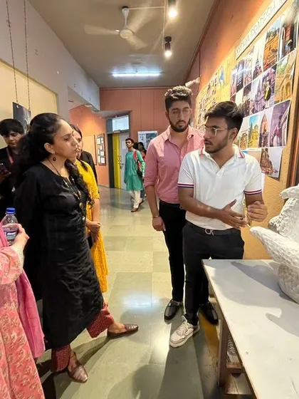 A student explains his sculptural model to visiting professors. These interactions are crucial for students to learn how to articulate their design concepts and receive valuable feedback from experienced professionals.