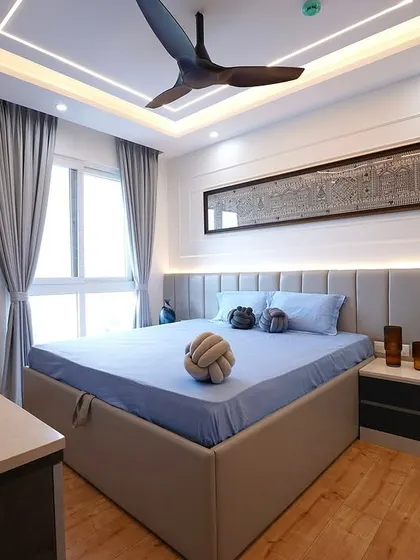 A contemporary bedroom design where clean lines meet geometric patterns. A long, elegant piece of art is mounted above the upholstered headboard, complemented by a sleek ceiling design.