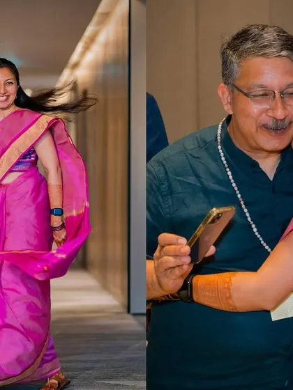 A candid moment of the bride twirling in her vibrant pink saree and sharing a warm hug with her father during her haldi event.
