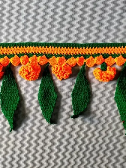 This toran was made with bright orange marigolds and crochet mango leaves, a perfect decoration for Navratri. It brings a festive and handmade warmth to the home.