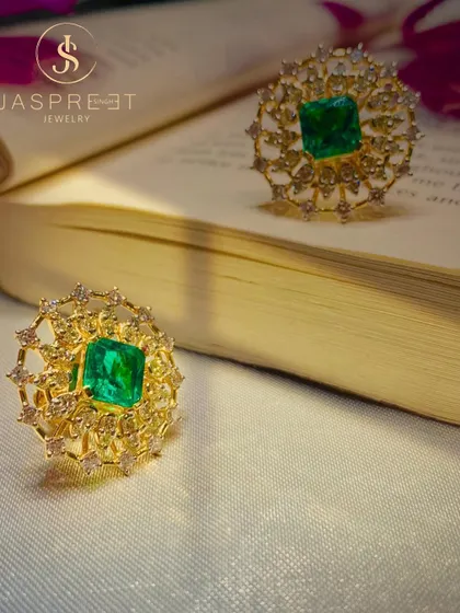 Two of my emerald and diamond cocktail rings, crafted in 22kt gold. The intricate, web-like setting of the diamonds creates a delicate frame for the rich green of the central emeralds.