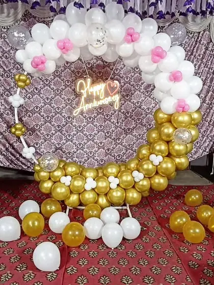 The full anniversary balloon hoop setup, with loose balloons scattered on the floor for a playful effect.