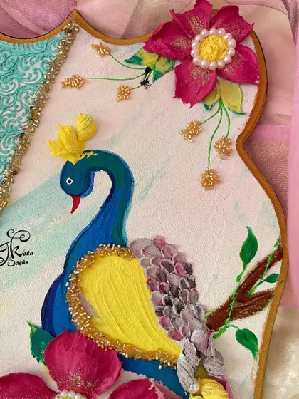 A close-up of the peacock's head and crown, showing the delicate details and golden accents.