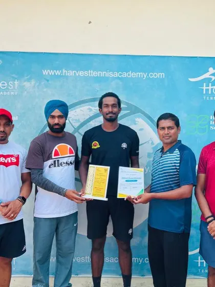Oges receiving his singles winner's trophy from the tournament officials in Jassowal.