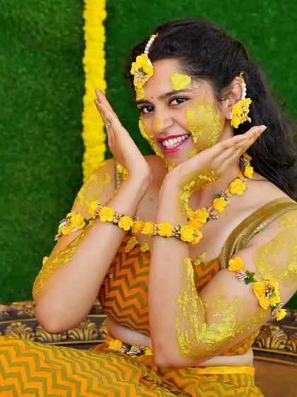 A fun and expressive shot of the bride-to-be enjoying her Haldi ceremony.
