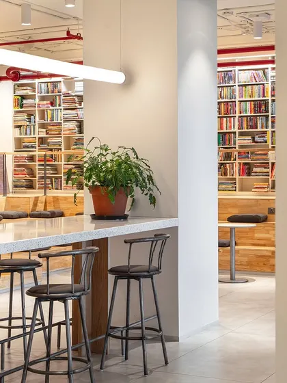 We designed the Penguin India office with a variety of seating options to support different work styles. This high-top coffee bar provides a casual spot for quick meetings or focused work, surrounded by floor-to-ceiling bookshelves that reinforce the company's literary identity.