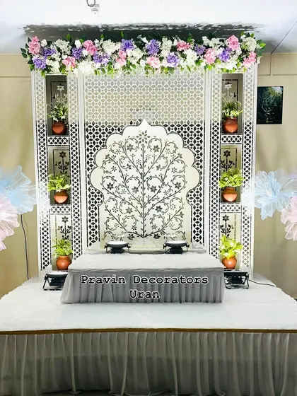 Here is an elegant, white-themed Ganpati decoration for a client's home. The centerpiece is a custom Tree of Life Jaali backdrop, complemented by a raised platform for the idol and built-in niches to display small plants and diyas.