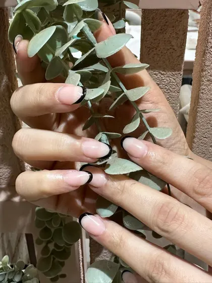 The contrast between the sheer pink base and the deep black tip makes this modern French manicure incredibly striking.