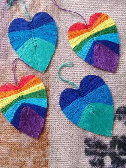 A collection of our boho vibrant leaf hangings. Each one is made by wrapping colorful threads to create these beautiful rainbow and cool-toned patterns.