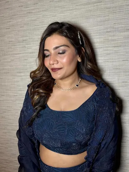 Sparkle in the eyes and soft curls on the side. This is a classic glam look, featuring a beautiful smokey eye with a pop of glitter, perfect for a Sangeet or reception.