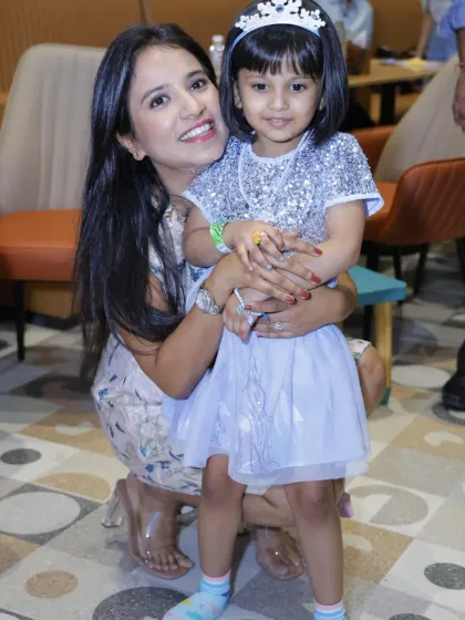 A mother and her little princess share a sweet moment during a party.