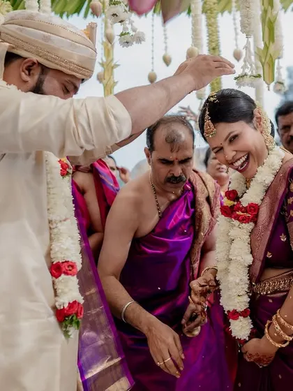 The fun and games of wedding rituals. This moment of laughter during a post-wedding game shows the playful spirit and strong bond between the couple and their families.