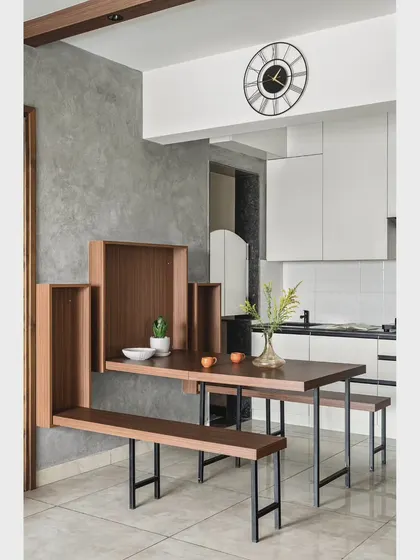 For this 850 sq.ft apartment, I designed a custom folding dining table and bench set. When expanded, it comfortably seats a family, and when folded, it becomes a sleek wall feature, ensuring clear circulation.