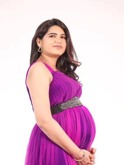 A simple and elegant studio portrait of a mom-to-be. This purple pleated gown is a comfortable and stylish option for a maternity shoot.