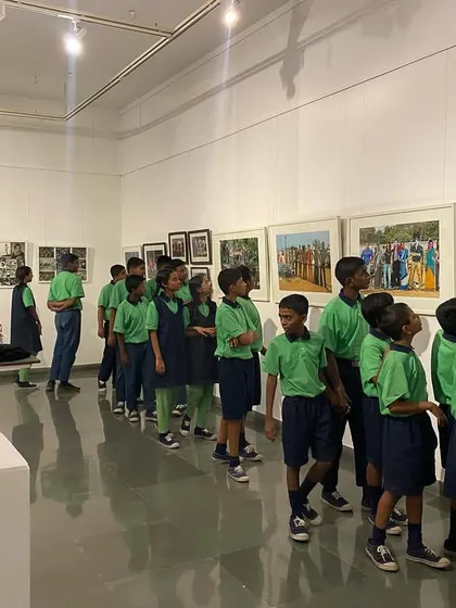 The young students looking at a series of colorful paintings depicting scenes from old films.