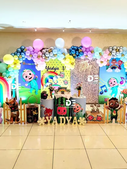 A bright and happy Cocomelon party for Yadya. This setup features a sequin backdrop, rainbow details, and plenty of characters to delight the little guests.