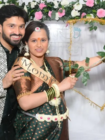 A playful moment during the baby shower ceremony, with the mom-to-be holding a decorative bow and arrow.