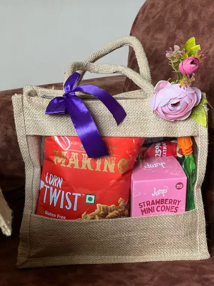 A simple yet effective corporate hamper in a jute bag. It's filled with snacks and a drink, making it a great option for casual corporate events or as a welcome gift for new employees.