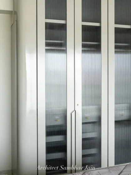 A seamless blend of elegance and function, this wardrobe features glossy PU shutters paired with vertical fluted glass inserts, adding rhythm and depth. The muted grey tones exude calm while softly rounded edges lend a sculptural softness.