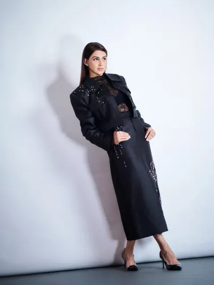 A full-body shot that showcases the modern elegance of Genelia's layered black look. The combination of textures is key here.