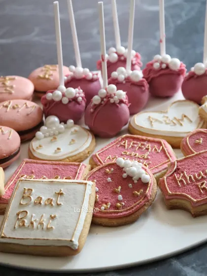 The full assortment of treats for an engagement platter, including macarons, cake pops, and a variety of custom-designed cookies.