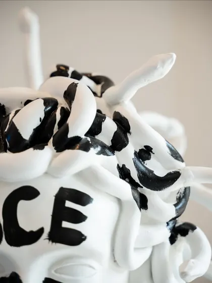 A detail of the snakes in Medusa's hair, rendered in white with bold black brushstrokes, adding to the graphic and powerful aesthetic.