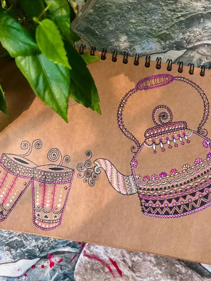 A cozy tea time scene with a kettle and glasses, all filled with detailed mandala patterns. This artwork was created on brown paper for a rustic, warm feel.
