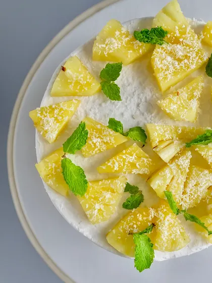 Escape to the tropics with my Coconut Pineapple Naked Cake. I use a soft coconut-vanilla sponge and fill it with a tangy pineapple compote and light whipped cream. Topped with fresh pineapple chunks, it’s a light and airy dessert perfect for any celebration.