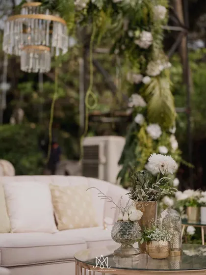 A detail shot of the lounge area, showing the soft textures of the cushions and the elegant floral arrangements on the coffee table.