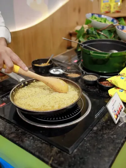 A chef in action at the live Maggi counter, stir-frying noodles to perfection. It's not just food; it's a fun culinary show for your guests.