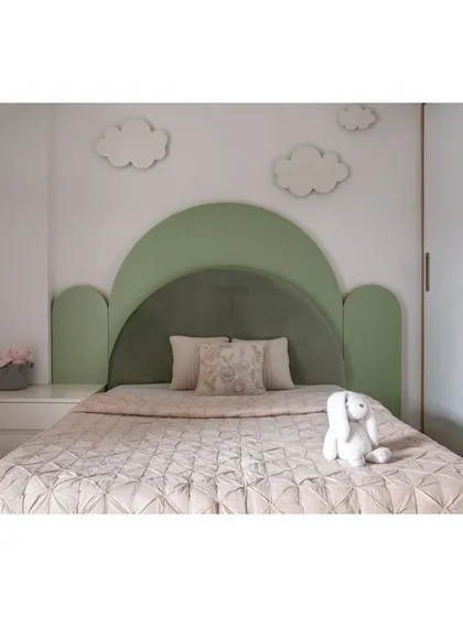 For this child's room, we designed a whimsical bed with a cloud-shaped headboard in a soothing green. It's a playful centerpiece that sparks imagination and creates a cozy spot for sweet dreams.