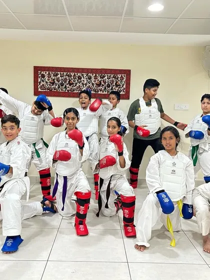 Students show off their full set of protective gear, including chest guards. Safety is our top priority during all sparring and self-defense training.