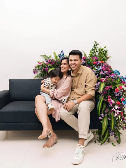 A beautiful family portrait for a first birthday, set against a stunning floral backdrop right in their home. This shows how we can create a stylish and personalized shoot in your own space.