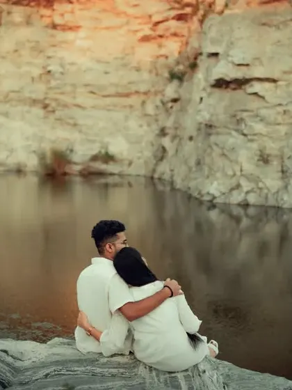 A quiet moment of togetherness for a couple sitting by the water, reflecting our ability to capture serene and contemplative pre-wedding photos.
