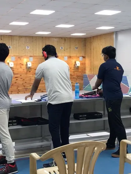 A perspective from just behind the firing line, showing shooters in their designated lanes. Safety and clear procedures are a top priority in our facility.
