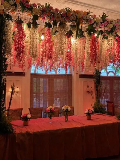 A beautifully decorated head table for a Catholic wedding. We created a canopy of hanging wisteria and flowers over the table, making it a stunning focal point within the venue.