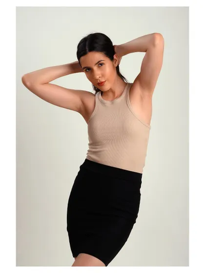 A simple and classic studio portrait. The neutral-colored top and clean background keep the focus on the model's natural beauty.