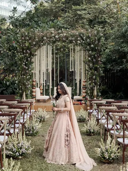 An enchanted garden wedding aisle at Taj The Trees, with the bride framed by a lush, natural archway.
