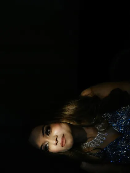 An artistic, low-key portrait of the bride Shriya, where light is used selectively to highlight her face, creating a mysterious and captivating image.