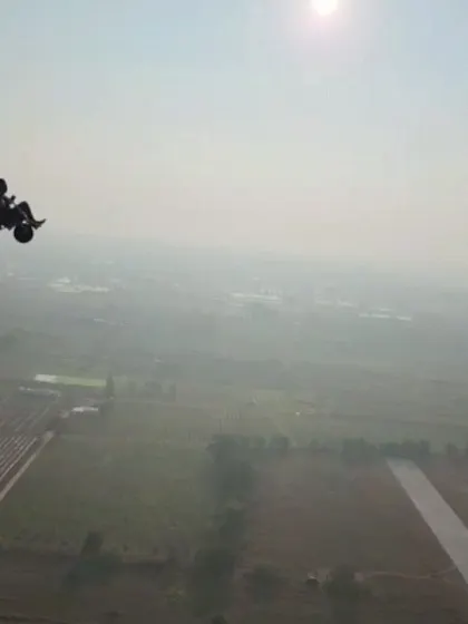 A clear shot of the paramotor rig against the morning haze, showing the powerful fan and comfortable seating for the tandem flight.
